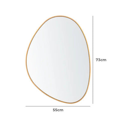 Modern asymmetrical wall mirror on a textured wall in gold