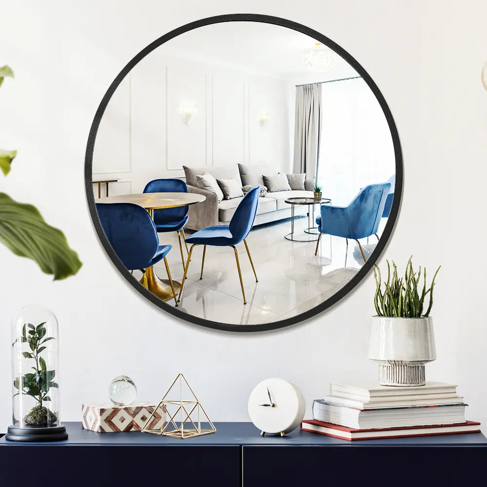 Round vanity mirror with aluminium frame reflecting in living room