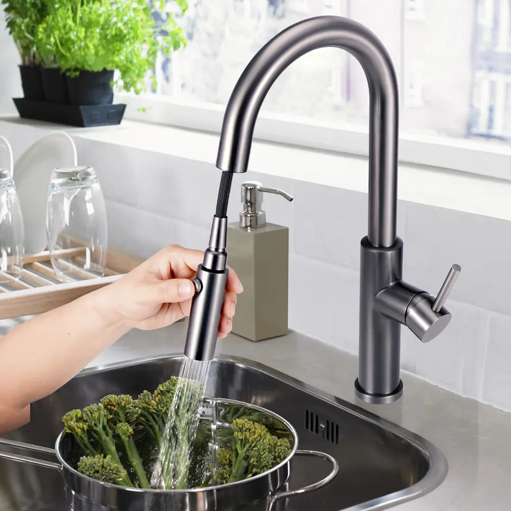 Hands using the pull-out feature on Arie gooseneck mixer tap