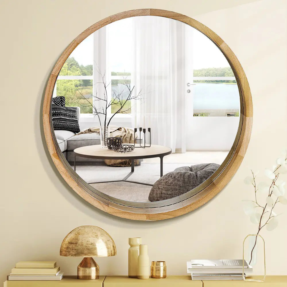 Libra Round Mirror hanging on wall with natural wood finish