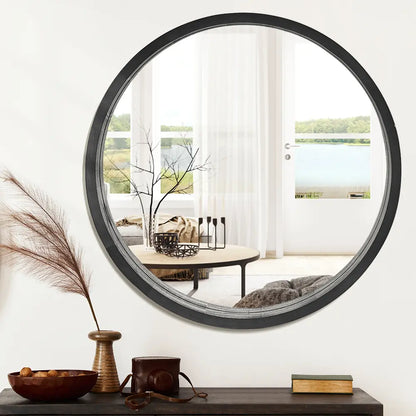 Libra Round Mirror hanging on wall with natural wood finish in black